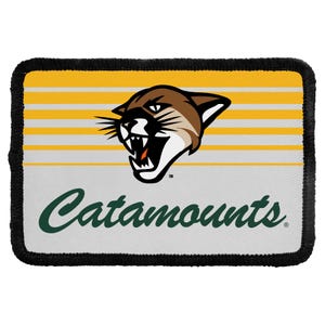 May include: A rectangular patch with a black stitched border featuring a graphic of a snarling mountain lion head above the word Catamounts in dark green script. The background consists of horizontal yellow and white stripes.