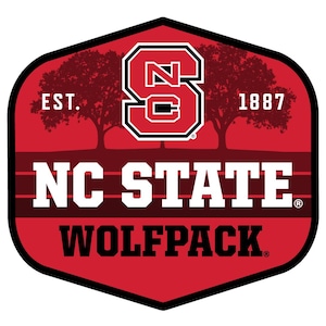 May include: A red and black NC State Wolfpack logo. The logo features the letters "NC STATE" above "WOLFPACK" in white block letters. The letter "S" is in the center, with the text "EST. 1887" on either side. The logo is in a shield shape.