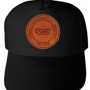 May include: Black trucker hat with a curved brim and mesh back. Features a circular leather patch with the text "Virginia Commonwealth University" and "VCU" in orange, along with "EST. 1838".