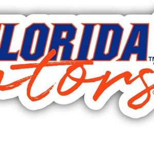 May include: A white sticker with the words "FLORIDA Gators" in blue and orange script. The sticker includes a floral design with orange and blue flowers and leaves.