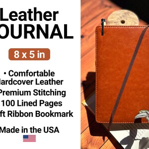 a brown leather journal sitting on top of a wooden table