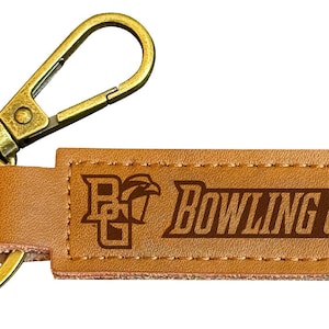 May include: A brown leather keychain with a gold metal key ring and a clip. The leather tag has the text "BOWLING GREEN" and a logo with the letters "BG" and a falcon.