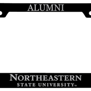 May include: Black metal license plate frame with the words "ALUMNI" at the top and "NORTHEASTERN STATE UNIVERSITY" at the bottom. The frame also features a gray eagle logo on each side.