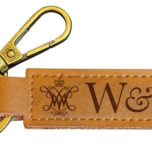 May include: A brown leather keychain with a gold metal key ring and a clasp. The keychain has the text "W&M" and a crest with a crown on it.
