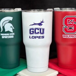three different colored tumblers sitting next to each other