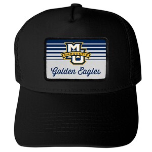 May include: A black trucker hat featuring a rectangular patch on the front. The patch displays the Marquette University MU logo in blue, gold, and white, with horizontal stripes and the text Golden Eagles written in a blue script font below.