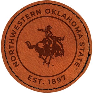 May include: A round, brown leather patch with the words "NORTHWESTERN OKLAHOMA STATE" encircling a graphic of a cowboy riding a bucking bronco. The text "EST. 1897" is at the bottom. The edge is stitched with black thread.