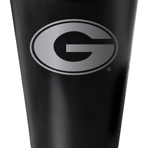 May include: A black stainless steel tumbler with a silver Green Bay Packers logo. The logo is a large "G" inside an oval.
