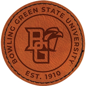 May include: A round, brown leather patch with the words "BOWLING GREEN STATE UNIVERSITY" in a circular pattern. The center features the letters "BG" with a falcon graphic and the text "EST. 1910". The patch has a stitched black border.