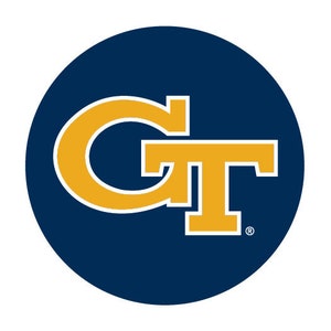 May include: A circular emblem featuring the letters "GT" in gold with a white outline, set against a deep navy blue background. The design is a stylized monogram, commonly used for branding and identification.