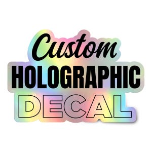 May include: A holographic decal featuring the text Custom HOLOGRAPHIC DECAL in black lettering. The word Custom is in a cursive script font, while HOLOGRAPHIC and DECAL are in a bold, sans-serif block font against a rainbow-colored background.