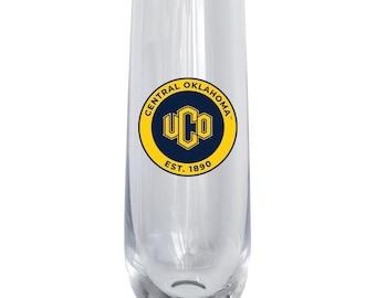 May include: A clear, stemless glass flute featuring a circular logo with a dark blue center, yellow border, and the text Central Oklahoma UCO Est. 1890. The glass has a smooth, cylindrical body with a rounded base and a wide, open rim.