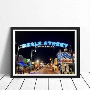 Pode incluir: Uma vista noturna da Beale Street em Memphis, Tennessee. A rua é ladeada por edifícios e postes de luz. Uma placa de néon diz "Beale Street Memphis".
