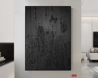 May include: Abstract black and white painting with a textured surface. The painting is framed in a black frame and is hanging on a white wall.