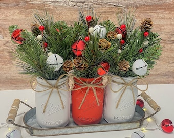 Pièce maîtresse de Noël dans un pot Mason : légumes verts d'hiver, baies, pommes de pin
