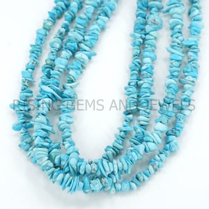 Puede incluir: Primer plano de varias hebras de cuentas de virutas de turquesa. Las cuentas son de un color azul claro vibrante y parecen estar ensartadas. La imagen está bien iluminada, destacando la textura y el color de las piedras preciosas. El texto "RISING GEMS AND JEWELS" es parcialmente visible.