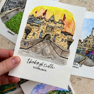 May include: Watercolor painting of Edinburgh Castle in Scotland. The castle is depicted in a yellow and brown color scheme with a red flag flying from the top. The painting is on a white background with the words "Edinburgh Castle" and "Edinburgh" written below the castle.