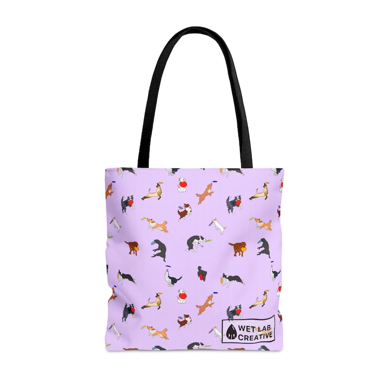 K&ouml;nnte beinhalten: Tragetasche mit hellviolettem Hintergrund und einem sich wiederholenden Muster von spielerischen Hundeillustrationen in verschiedenen Posen. Die Tasche hat schwarze Griffe und den Text "WET LAB CREATIVE" unten rechts.