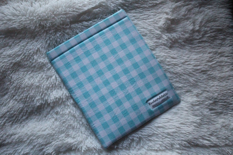 May include: A blue and white checkered book cover with the text "Bookendshells" printed on the bottom right corner.