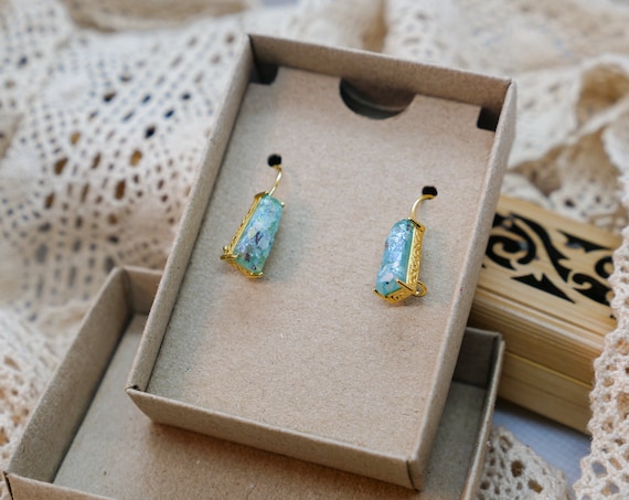 Earrings set with actual 2,000-year-old Roman glass — each piece has unique iridescent patina developed over millennia, genuinely one-of-a-kind by definition.