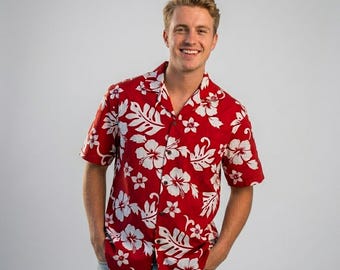 Op de afbeelding: Een overhemd met korte mouwen en knoopsluiting in een levendige rode kleur met een herhalend patroon van witte hibiscusbloemen en tropische bladeren. Het kledingstuk heeft een klassieke kraag, een knoopsluiting aan de voorzijde en een pasvorm.