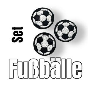 Könnte beinhalten: Set aus drei schwarz-weißen Fußball-Patches. Die Patches sind mit einem klassischen Fußball-Design bestickt. Das Wort "Set" steht über den Patches, und das Wort "Fußbälle" steht darunter.