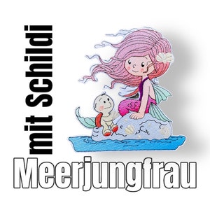 Könnte beinhalten: Gestickter Aufnäher mit einer pinkhaarigen Meerjungfrau, die auf einem Felsen mit einer kleinen Schildkröte sitzt. Die Meerjungfrau hat einen lila Schwanz und trägt ein Muschelhaarband. Der Text "Meerjungfrau mit Schild" ist unter dem Bild sichtbar.