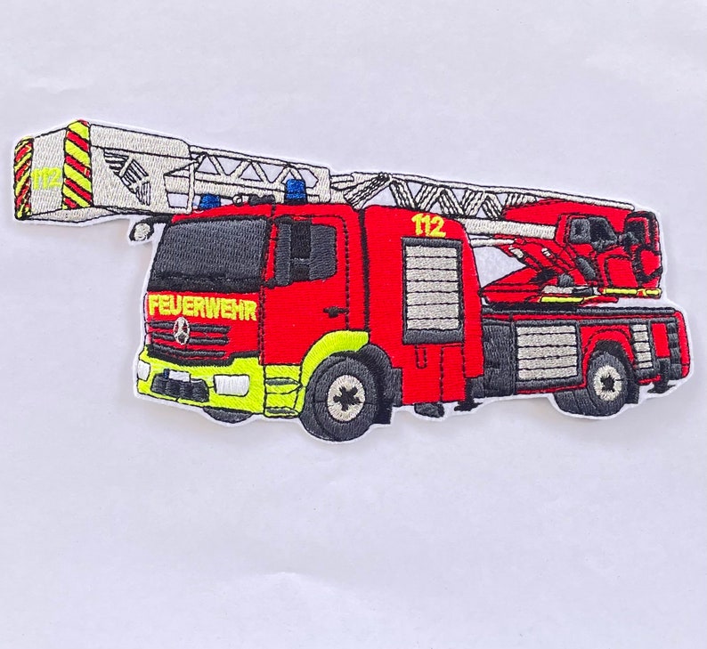 May include: Red and white embroidered patch of a fire engine with a ladder, the words "FEUERWEHR" and "112" are visible on the engine.
