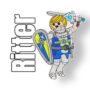 Könnte beinhalten: Gestickter Aufnäher eines Ritters mit Schwert und Schild. Der Ritter trägt eine blaue und gelbe Rüstung und einen weißen Helm. Der Aufnäher trägt den Schriftzug "Ritter" in schwarzer Schrift.