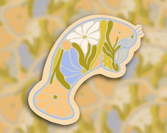 May include: A sticker featuring a manatee design filled with floral elements. The manatee is outlined in light blue, with a cream-colored border. The interior features white, orange, and yellow flowers, and green leaves. The background is a pattern of similar manatee designs.