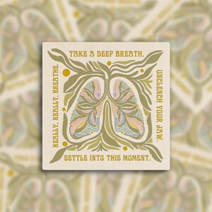 May include: Square art print with a beige background and a stylized illustration of lungs in pastel colors. The design includes botanical elements and text that reads "Take a deep breath. Really, really, breathe. Unclench your jaw. Settle into this moment."