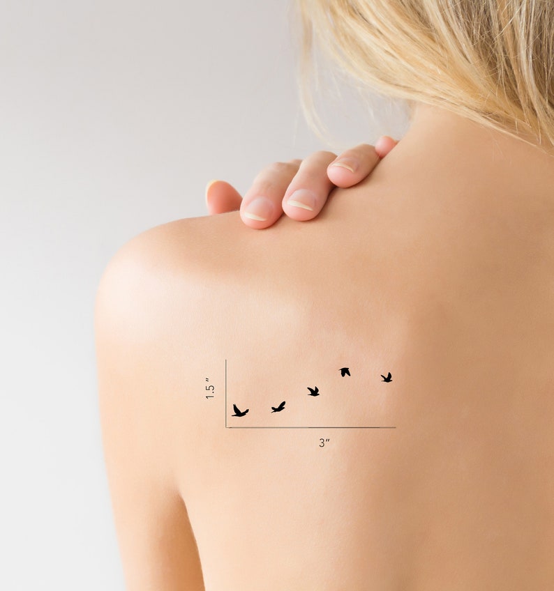 May include: A temporary tattoo of a flock of five black birds flying in a diagonal line. The tattoo measures 1.5 inches tall and 3 inches wide.