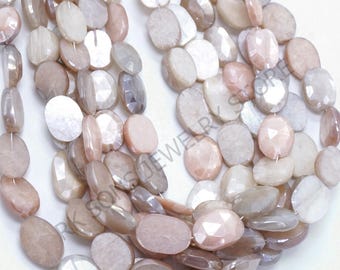May include: A collection of faceted, oval moonstone beads in peach, cream, and grey hues. The beads have a polished, iridescent finish and are strung together. The gemstones are displayed against a white backdrop.