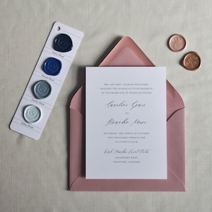 Puede incluir: Conjunto de invitaci&oacute;n de boda con una tarjeta blanca con escritura elegante, dentro de un sobre rosa empolvado. Una tarjeta de muestra de color muestra sellos de cera azul marino, real, polvoriento y azul beb&eacute;. Tambi&eacute;n hay dos sellos de cera florales adicionales.