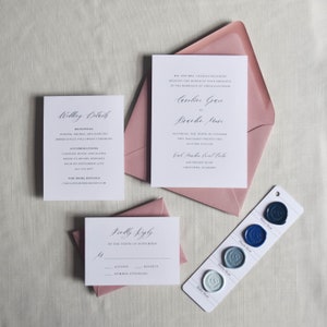 Puede incluir: Un conjunto de papeler&iacute;a de boda con tarjetas blancas y caligraf&iacute;a elegante, que incluye una invitaci&oacute;n, una tarjeta de confirmaci&oacute;n de asistencia y una tarjeta de detalles, junto con sobres rosas. Una muestra de color muestra opciones de sellos de cera azules.