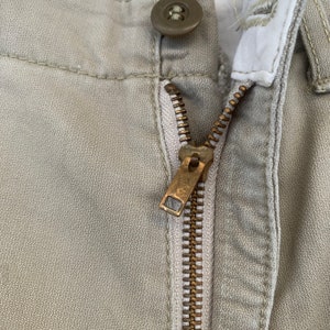 May include: A set of three ceramic mugs with a speckled, matte finish. Each mug features a different color: light blue, cream, and gray. The mugs have a simple, modern design with a rounded shape and a comfortable handle.