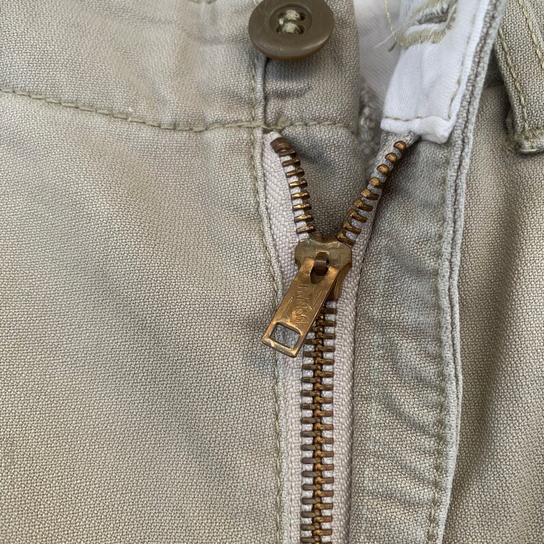 May include: A set of three ceramic mugs with a speckled, matte finish. Each mug features a different color: light blue, cream, and gray. The mugs have a simple, modern design with a rounded shape and a comfortable handle.