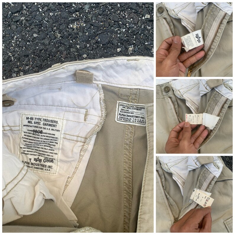 May include: Khaki-colored M-65 type trousers with visible labels. The labels include text such as "MIL SPEC. GARMENT" and "ALPHA INDUSTRIES INC." The trousers have a zipper and button closure. The garment is designed for the U.S. Military.