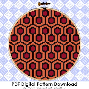 Op de afbeelding: Een digitaal kruissteekpatroon voor het iconische Overlook Hotel-tapijt uit de film "The Shining". Het patroon heeft een herhalend geometrisch ontwerp van rode en oranje zeshoeken.