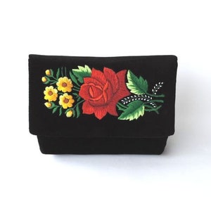 May include: Black velvet clutch with embroidered red rose and yellow flowers.
