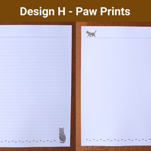 May include: Two white sheets of paper with a cat and paw print design. One sheet is lined, and the other is blank. The text "Design H - Paw Prints" is at the top. The cat and paw prints are in a grey colour.