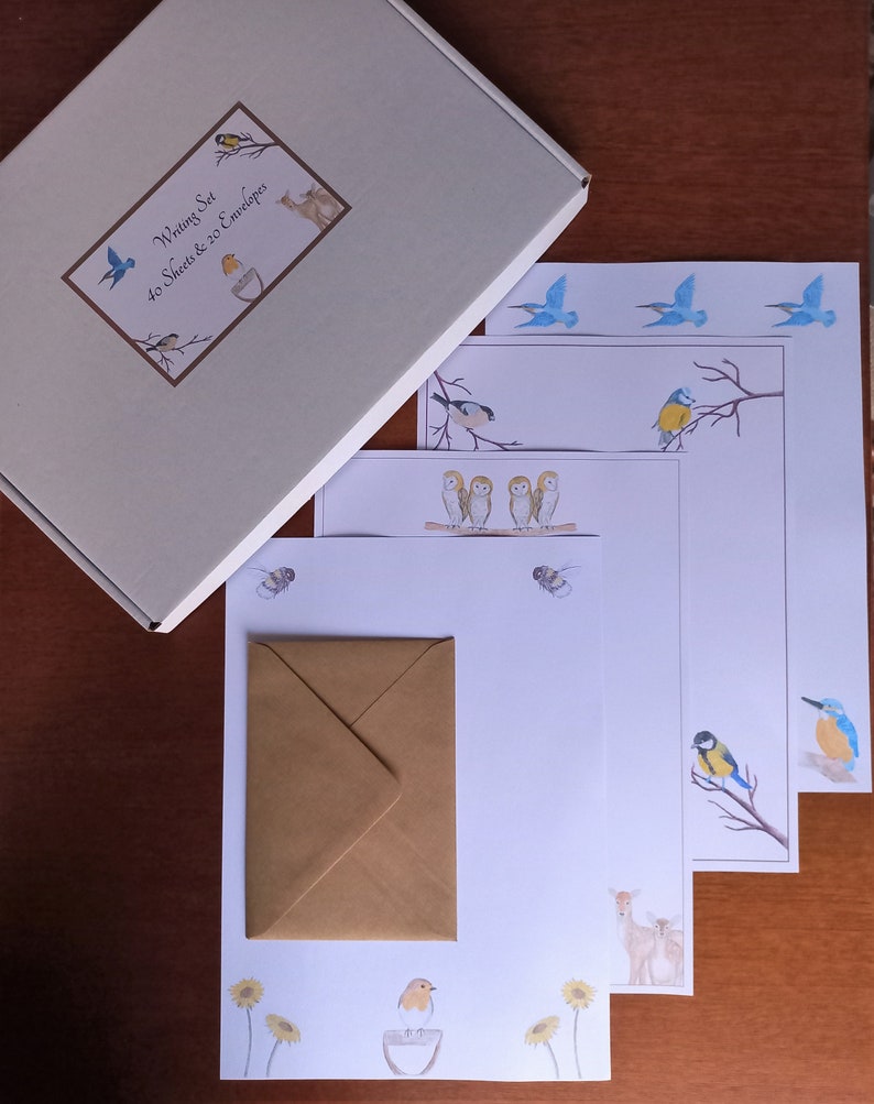May include: A writing set with a cream box and stationery featuring watercolour illustrations of birds, bees, and flowers. The set includes 40 sheets and 20 envelopes. The stationery has a variety of bird designs, including bluebirds, owls, and robins.