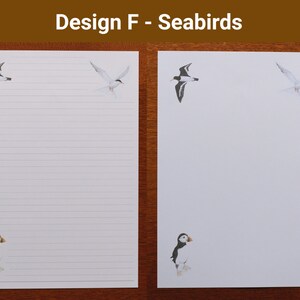 May include: White lined stationery with seabird illustrations. The design includes a puffin, a tern, and another seabird. The text "Design F - Seabirds" is at the top. The stationery is on a wooden surface.