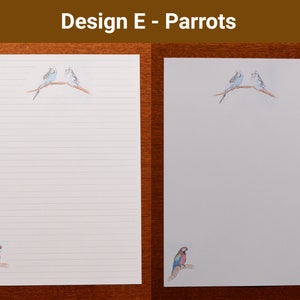 May include: White stationery featuring a parrot design. Two blue and white birds are perched on a branch at the top of the page. A single parrot is in the bottom corner. The text "Design E - Parrots" is at the top.