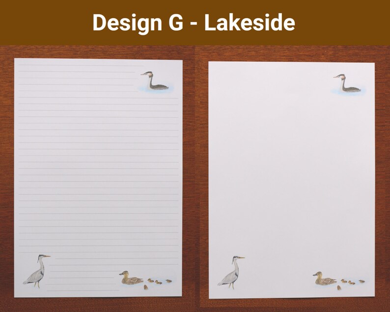 May include: Two sheets of white stationery with a lakeside theme. One sheet is lined, the other is blank. Each sheet features illustrations of a bird in water and a heron. The text "Design G - Lakeside" is at the top.
