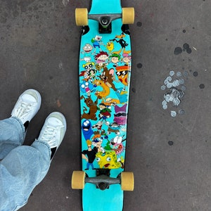 May include: A turquoise longboard skateboard with black trucks and wheels. The deck features a colorful graphic of cartoon characters from popular animated television shows, including SpongeBob SquarePants, Dexter's Laboratory, and The Powerpuff Girls.