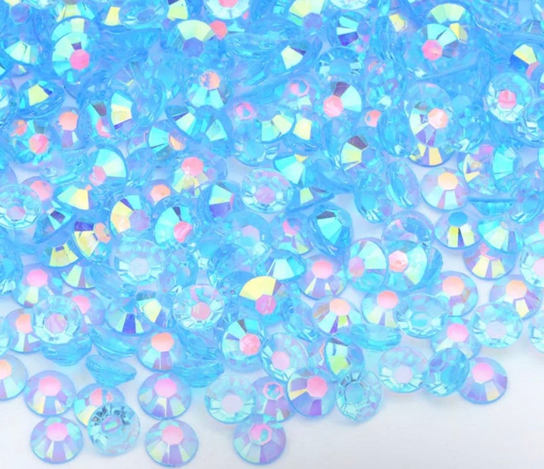 May include: A large quantity of small, iridescent, light blue, round, flat-backed rhinestones.