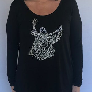 May include: Black long-sleeved shirt with a sparkly silver angel design on the front.
