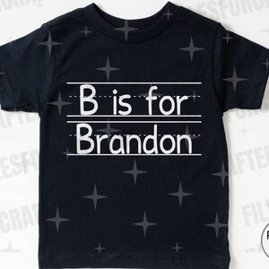 Puede incluir: Camiseta negra con texto blanco que dice "B is for Brandon" en una camiseta negra.