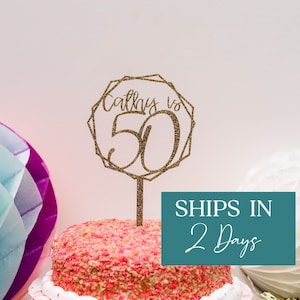 May include: Gold glitter cake topper with a geometric frame and the text "Always 50".